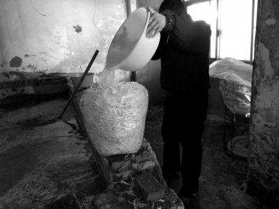 作坊內(nèi)工人用攪拌有漂白粉的藥水給豆芽增白。