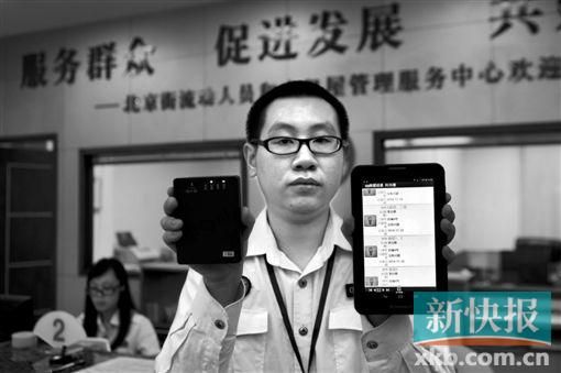 　越秀區(qū)北京街出租屋外來暫住人員管理服務中心的工作人員展示到出租屋登記來穗人員信息的儀器。