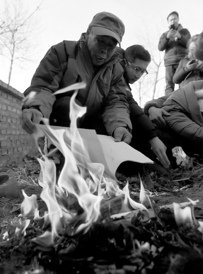 李三仁在兒子墳前焚燒再審無罪判決文書的復(fù)印件。新華社發(fā)