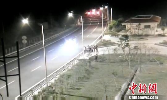 看到車輛經(jīng)過(guò)，孩子們便急忙跑到一旁的花圃上?！【焦﹫D　攝