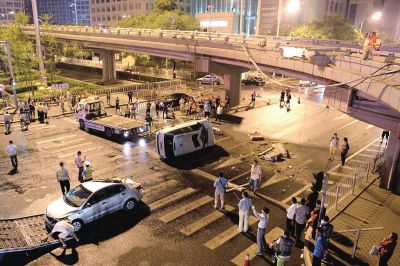 路虎沖下國貿(mào)橋砸中一輛起亞轎車，橋上厚達(dá)幾十厘米的水泥護(hù)欄被撞斷，碎石四處散落，數(shù)十群眾在現(xiàn)場圍觀。