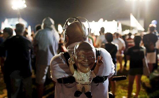 9月4日，新加坡，執(zhí)政黨的一場(chǎng)集會(huì)上，一名支持者背著一個(gè)李光耀的人偶。