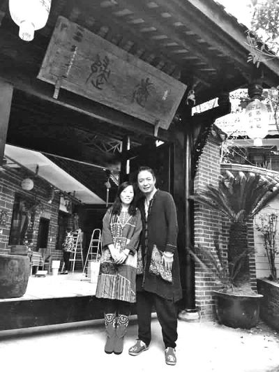 顧少強和丈夫在自己的客棧前合影,作為結婚照。照片由受訪者提供