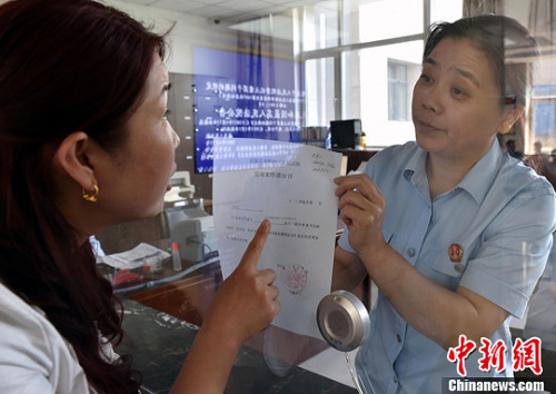 資料圖：2015年5月4日，河北石家莊市橋西區(qū)人民法院立案庭庭長(zhǎng)齊燕正在為立案人辦理相關(guān)手續(xù)，完成整個(gè)過(guò)程只用了5分鐘。當(dāng)日是立案登記制改革首個(gè)工作日，該院共立案36件，立案率達(dá)到90%。中新社發(fā) 翟羽佳 攝