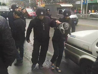 達(dá)州市警方押解剛被抓獲的犯罪嫌疑人褚思練（裹頭巾者）。 本組圖片/新華社