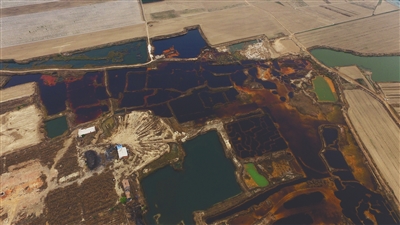 4月19日，廊坊市大城縣南趙扶鎮(zhèn)，津保路以北約八九百米處，一個(gè)巨大的污水坑中，水體呈現(xiàn)紅褐色。 新京報(bào)記者 尹亞飛 攝