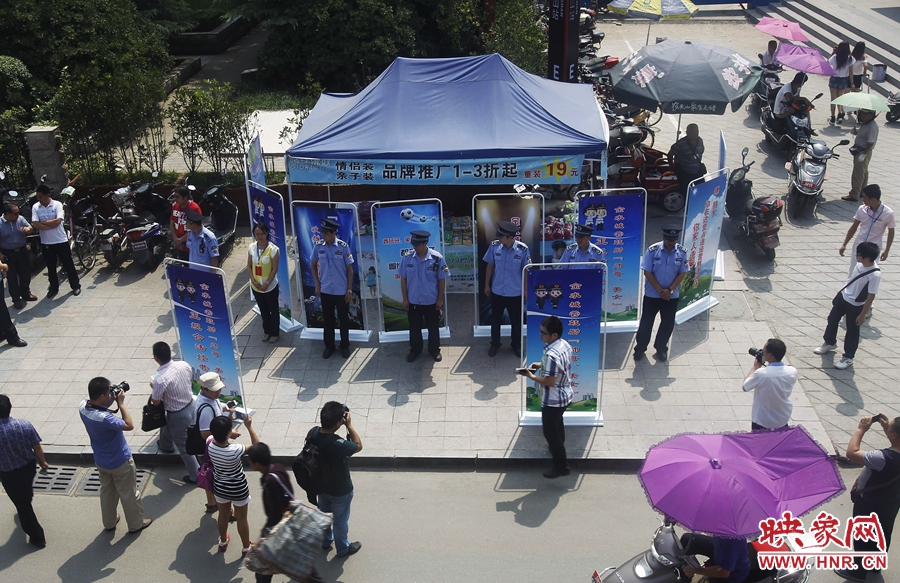 執(zhí)法人員用宣傳牌圍擋占道經(jīng)營攤位。