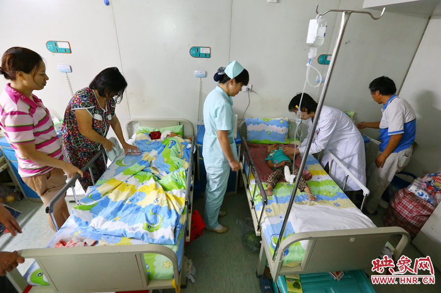 手術(shù)前，畫面右側(cè)的大龍正在接受醫(yī)生的檢查，左側(cè)的小龍還在熟睡。