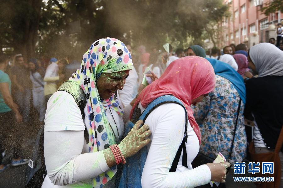 10月16日，在埃及首都開羅，兩名女青年在“彩色跑”活動中躲避人們拋撒的彩色粉末。