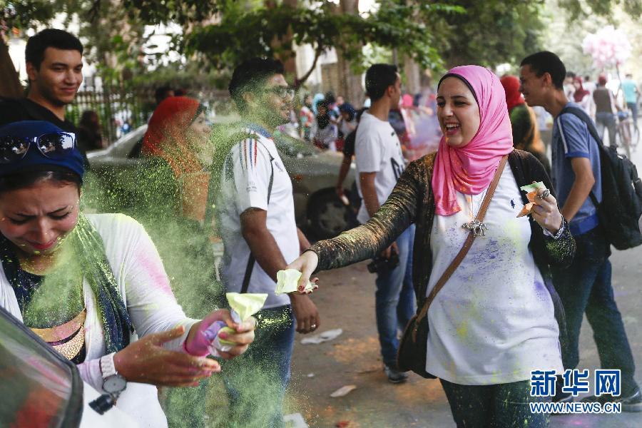 10月16日，在埃及首都開羅，一名女青年在“彩色跑”活動中拋撒彩色粉末。