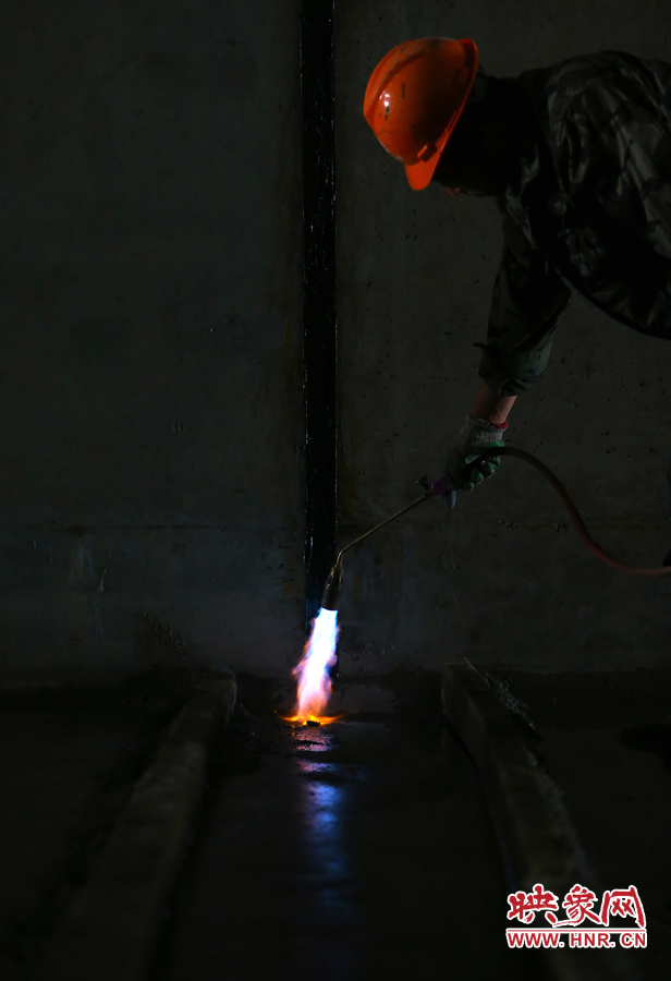 工人師傅用噴槍烘干地面，便于做防水處理