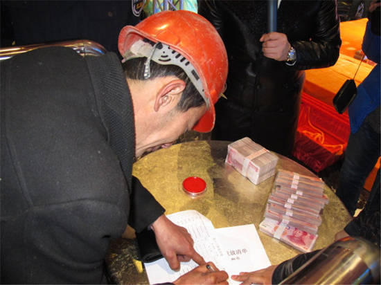農(nóng)民工在現(xiàn)場(chǎng)領(lǐng)取工資。