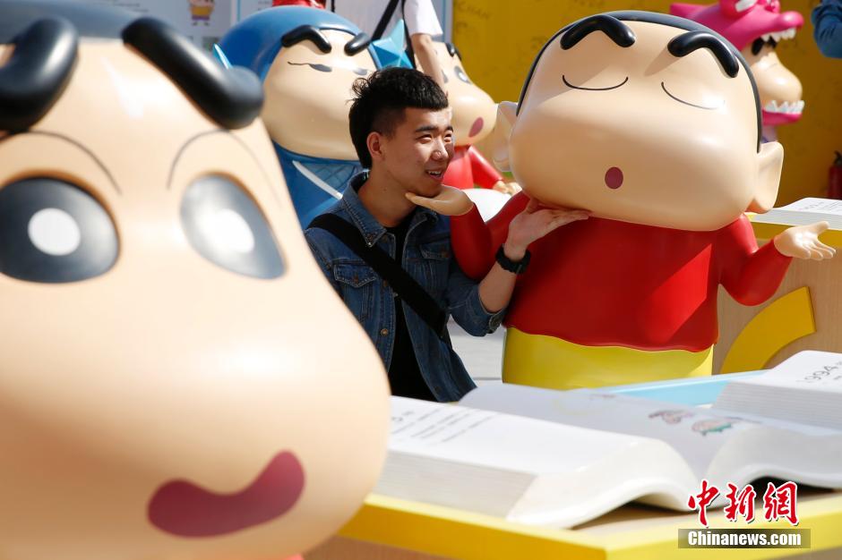 4月22日，游客與蠟筆小新合影?！跋灩P小新25周年紀念特展”日前在北京開展，吸引了不少市民游客。