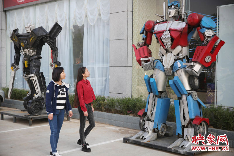 10月14日，市民在參觀河南省平頂山市寶豐縣一家企業(yè)門(mén)前的“變形金剛”。