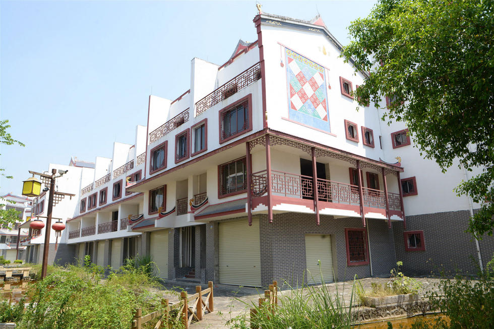 2016年7月26日，村民在廣西來賓市忻城縣隆達(dá)山水福城荒廢別墅間放牛。