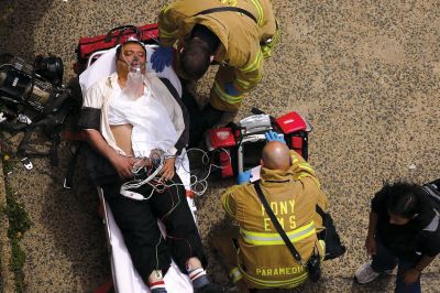 2日，救援人員在美國(guó)紐約地鐵事故車輛內(nèi)緊急疏散一名受傷乘客。圖/CFP