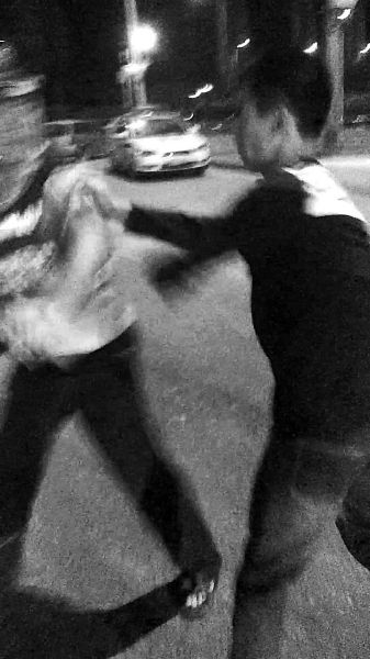 一名男子扯著民警的反光背心一路追打。