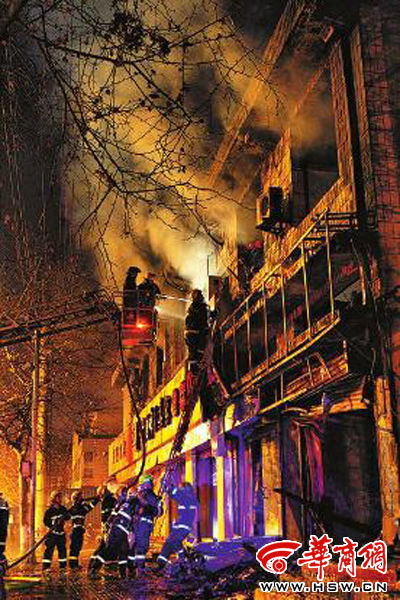 昨日22時(shí)10分，西安市豐慶路南小巷南口，消防官兵架梯子登上二樓施救 本組圖片由本報(bào)記者 閆文青 攝