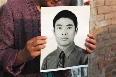 5月19日，朝陽北路，母親捧著張東文的遺像。新京報記者 侯少卿 攝