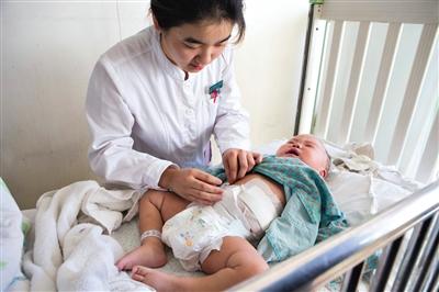 昨日，北京兒童醫(yī)院，護(hù)士為即將出院的被扎鋼針女?huà)霗z查傷口恢復(fù)情況。記者 高瑋 攝