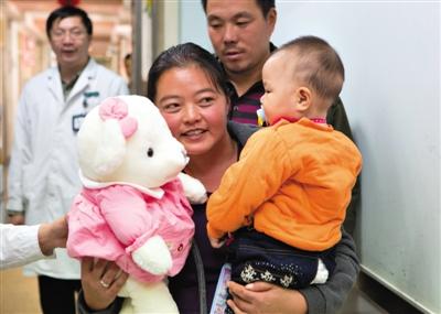 昨日上午，被扎針女?huà)氲哪赣H抱著孩子和醫(yī)護(hù)人員送的玩偶準(zhǔn)備出院，院方稱(chēng)孩子術(shù)后恢復(fù)良好。記者 高瑋 攝