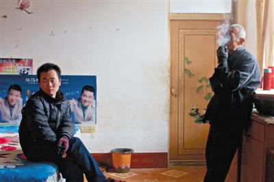 父親抽煙，兒子不語。逃跑的越南新娘，給袁迎賓父子帶來的是失落。新京報(bào)記者 周崗峰 攝