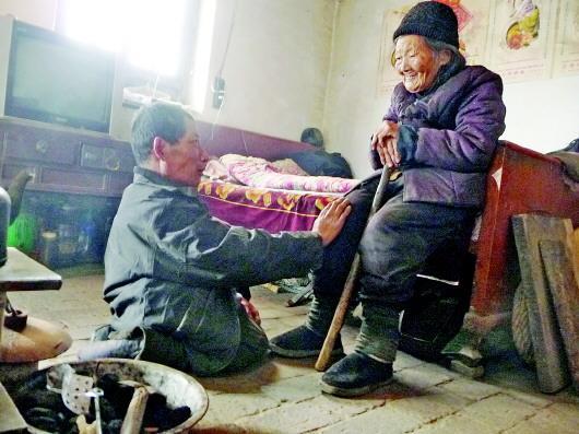 52歲的劉蘭山每天靠爬行照顧90歲的老母親。孫國祥 攝