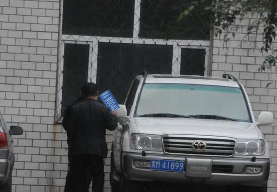 程父與程的“司機(jī)”在居住小區(qū)內(nèi)將黑AB0040車牌更換為黑M41899車牌，倆車牌號均為空號