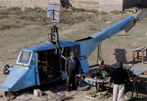 哈蒂姆·卡迪姆·薩爾曼正與工人交談，背后就是他正在制造的直升機(jī)