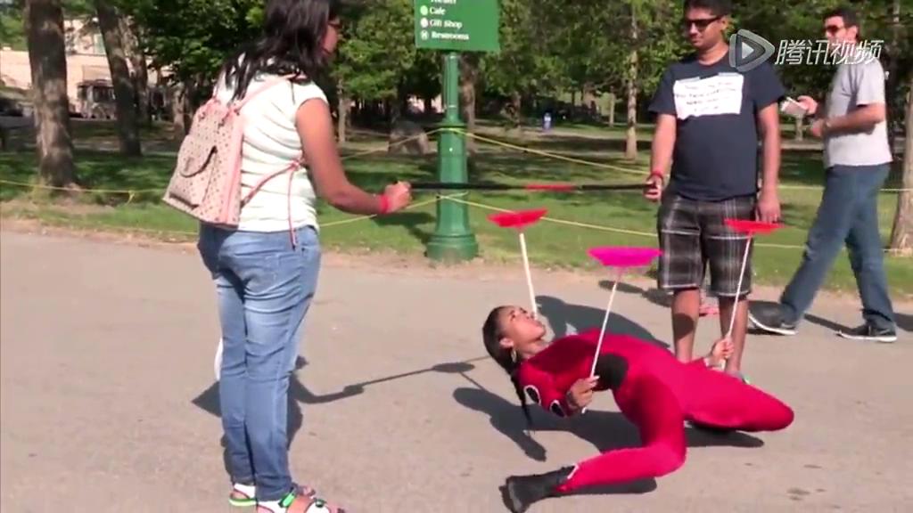 美少女彎腰穿過(guò)啤酒瓶高度欄桿 成功穿行轎車底部