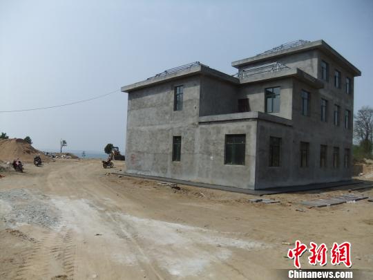 鴨河水庫庫區(qū)邊的新建別墅，一面墻上寫著“拆”，另一邊在加緊施工。吳揚　攝