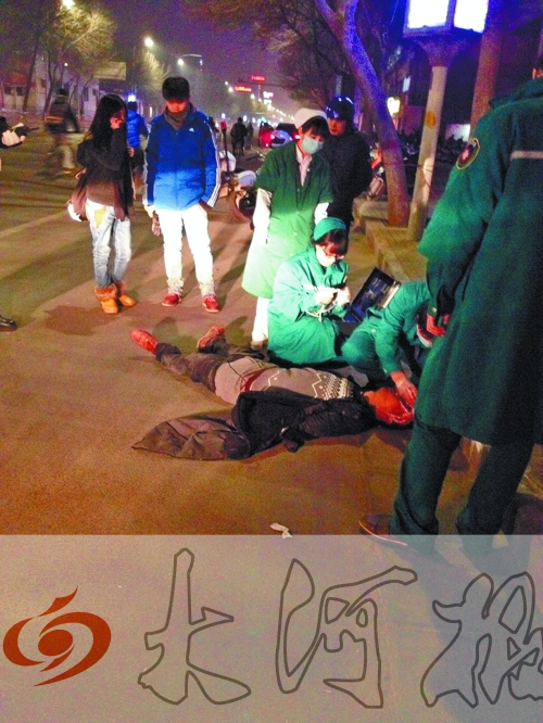 醉漢躺在地上，醫(yī)護(hù)人員對其進(jìn)行檢查。